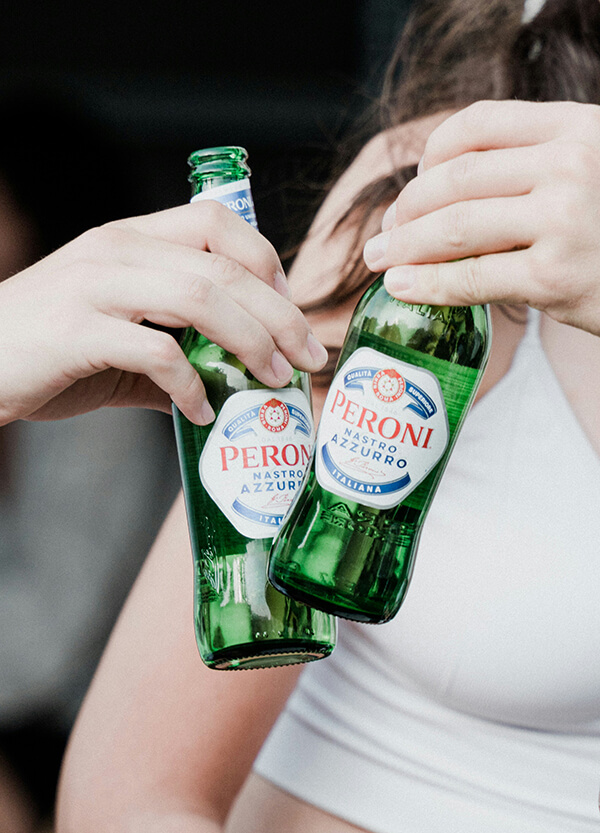 Lagers - two hands holding Peroni bottles - Champers Drinks
