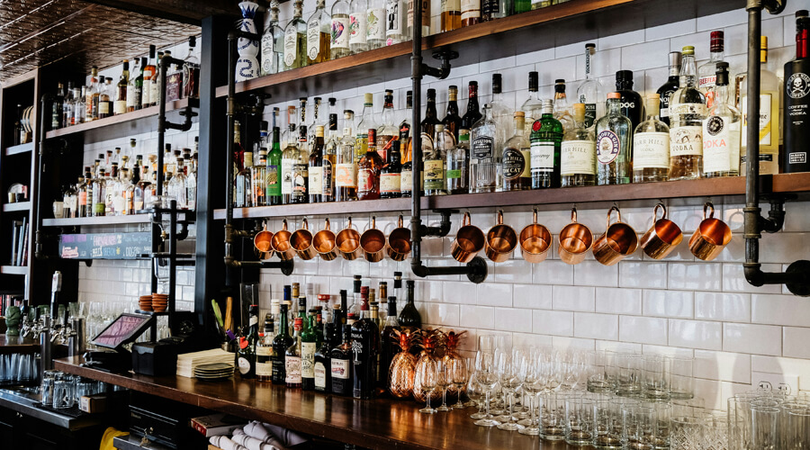 Spirit bottles on a bar shelf - Champers Drinks