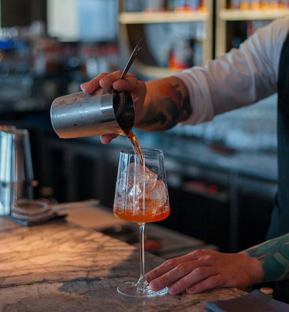 bartender pouring a cocktail - Champers Drinks